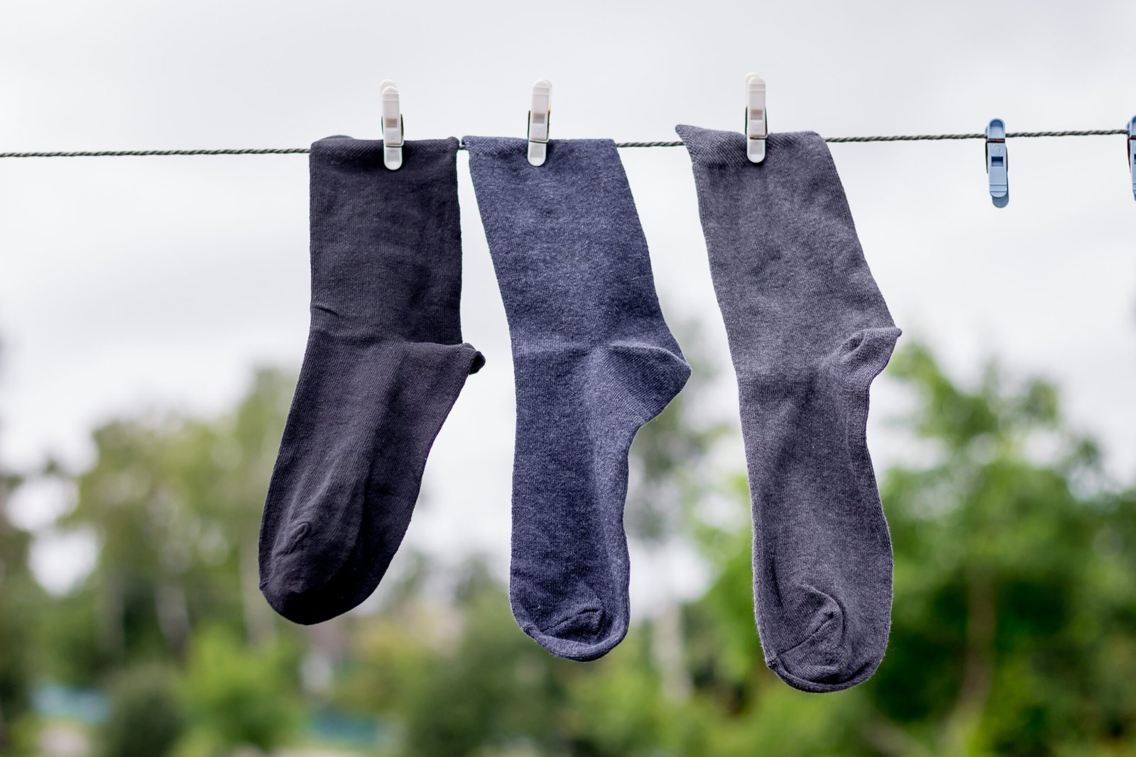Various socks in color, hung in a row for drying