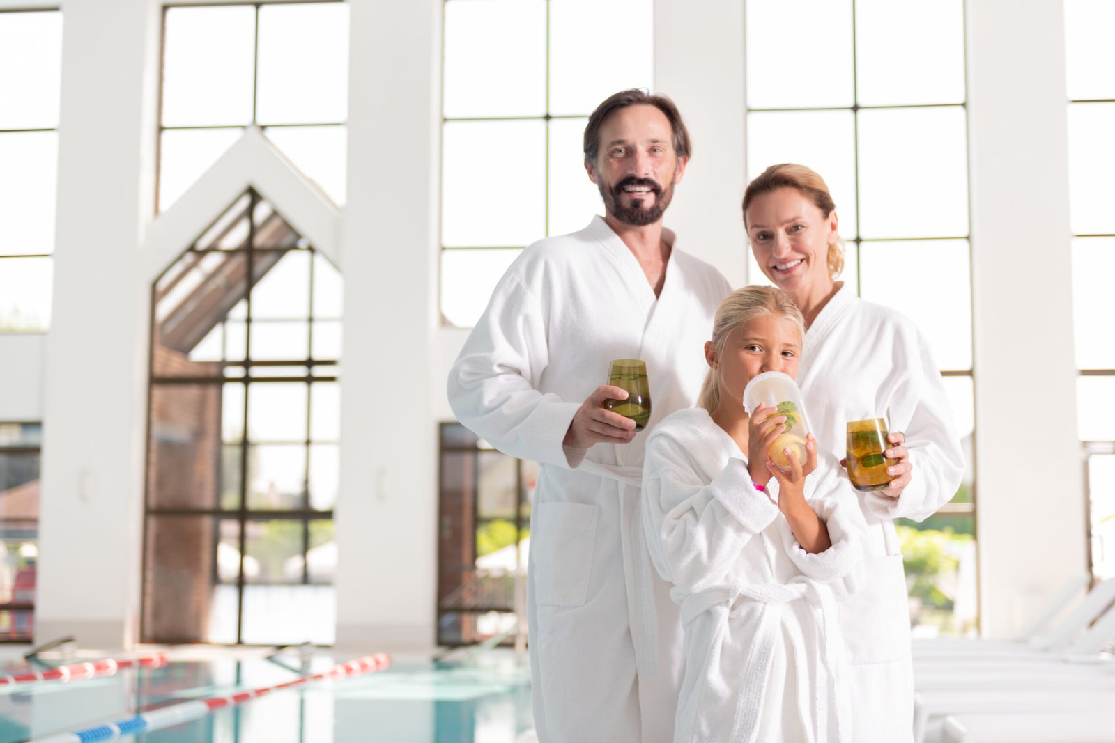 Healthy lifestyle. Positive nice family looking at you while drinking healthy lemonade together