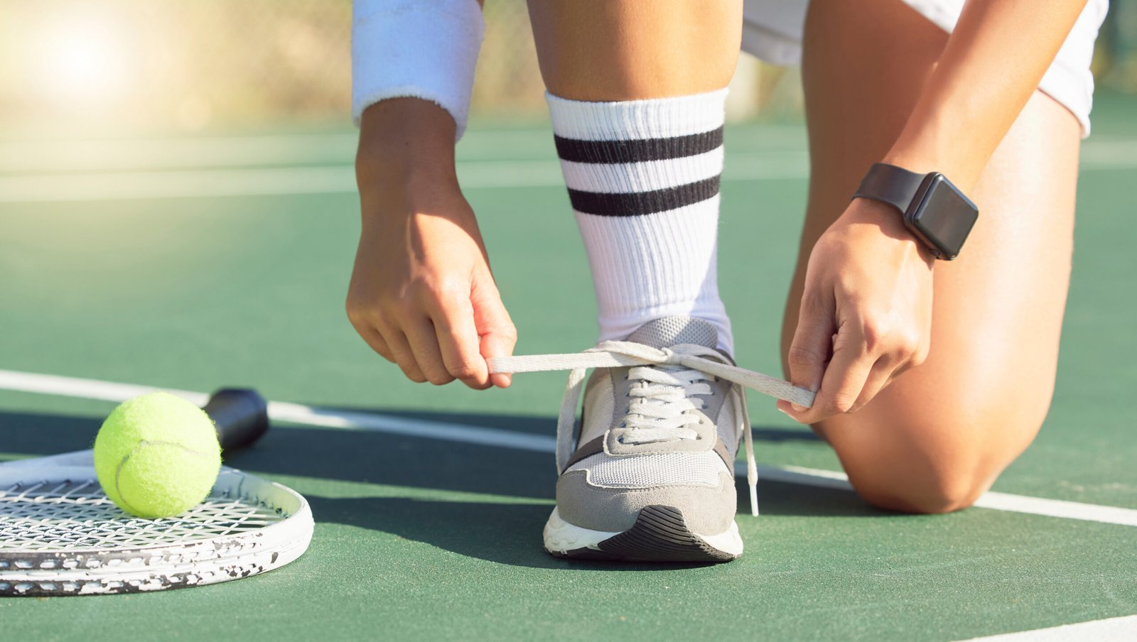 Tennis, sports and woman tie shoes ready for match, game or training. Exercise, fitness and female with ball, racket and on sport court preparing for athletics, competition or wellness health workout.