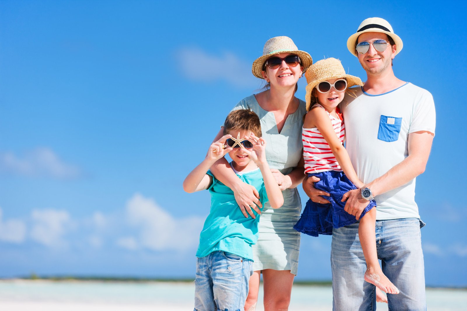 Happy beautiful family posing at beach during summer vacation