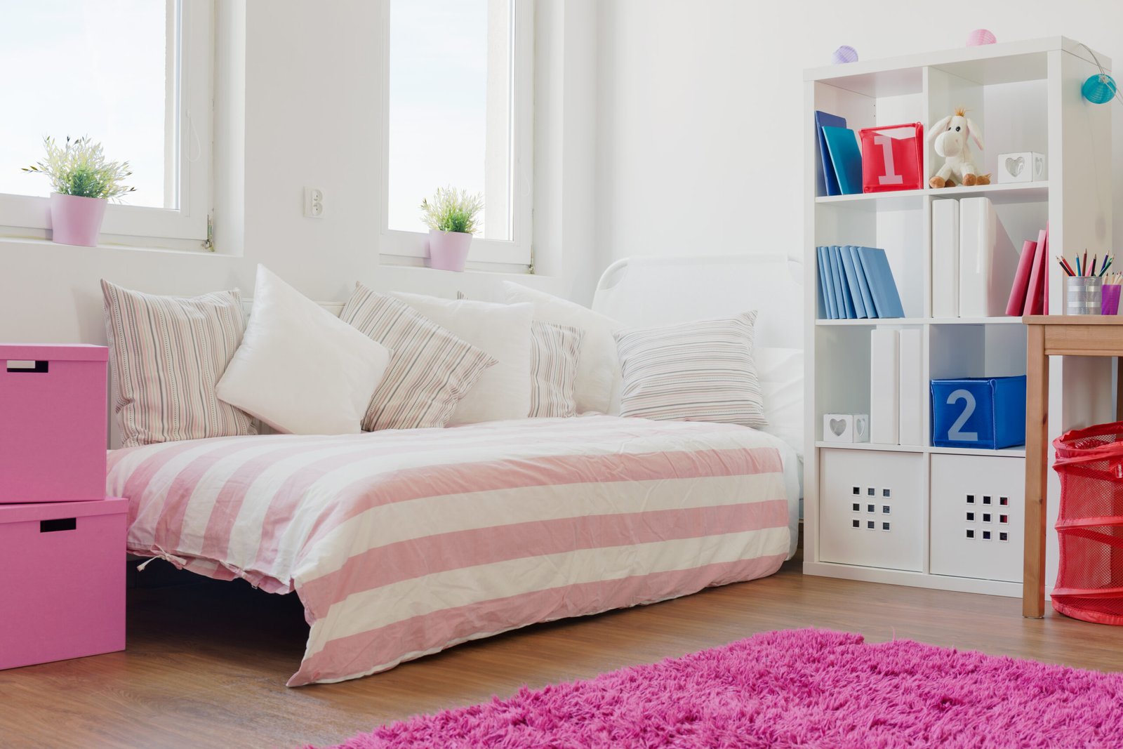 A lot of cushions on the bed in girl's room