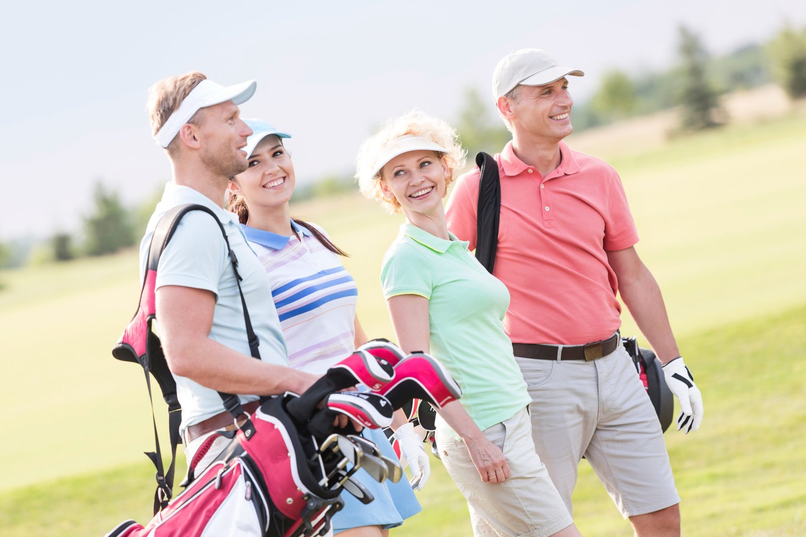 Happy friends walking at golf course