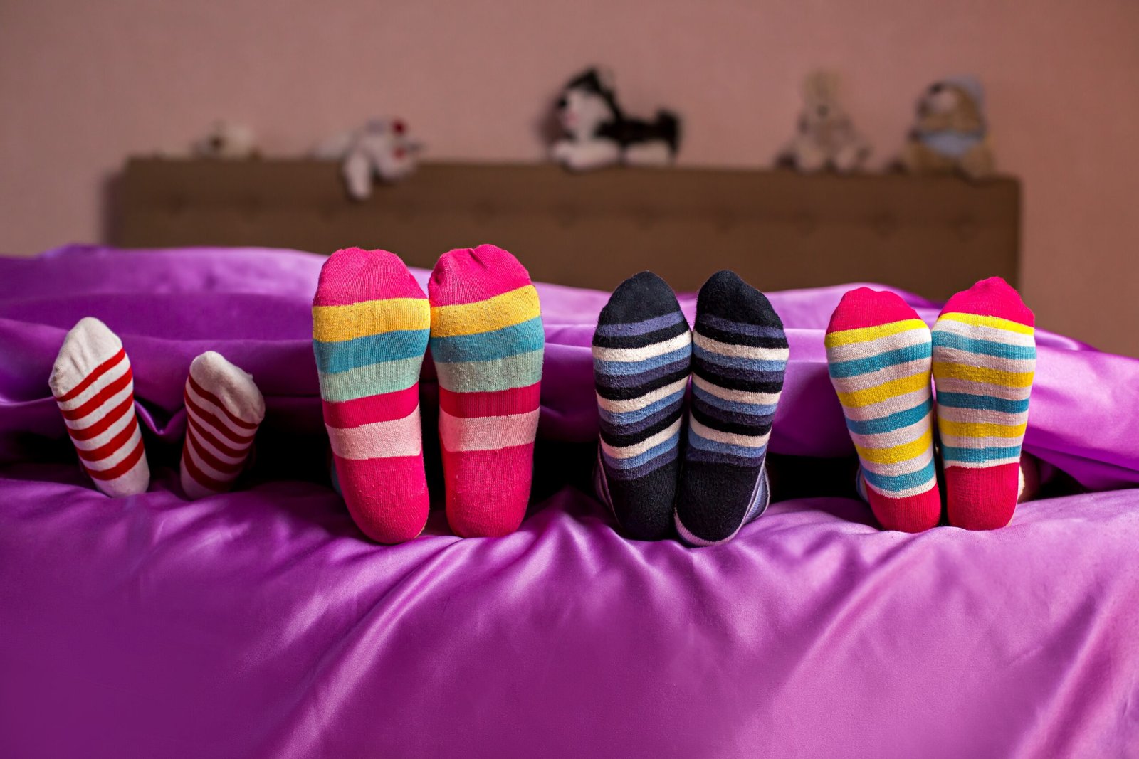 Children's feet in colorful socks. Kid's colorful bright socks. They think they're hidden. Hide and seek.
