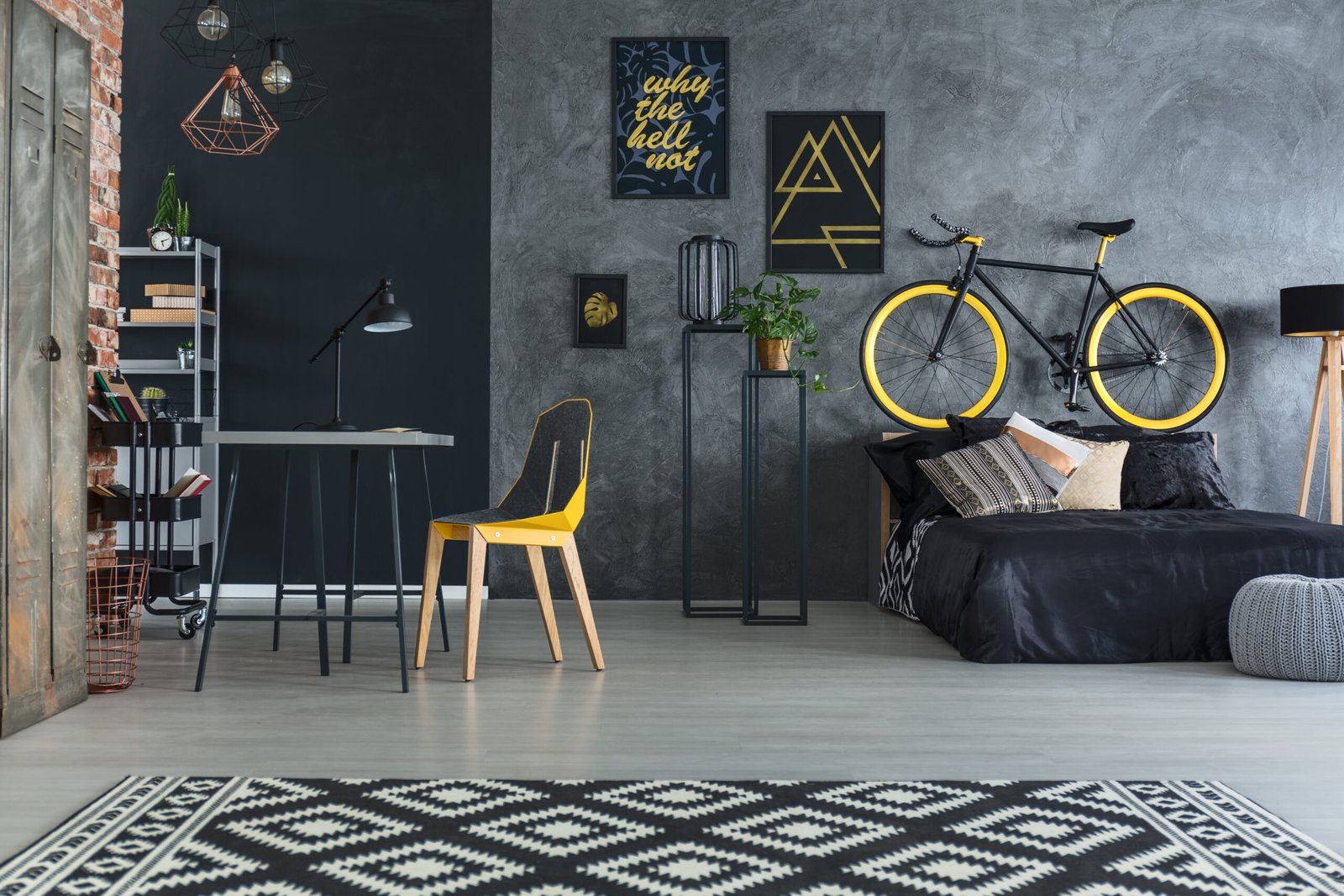 Hipster bedroom with bed, desk, chair and brick wall