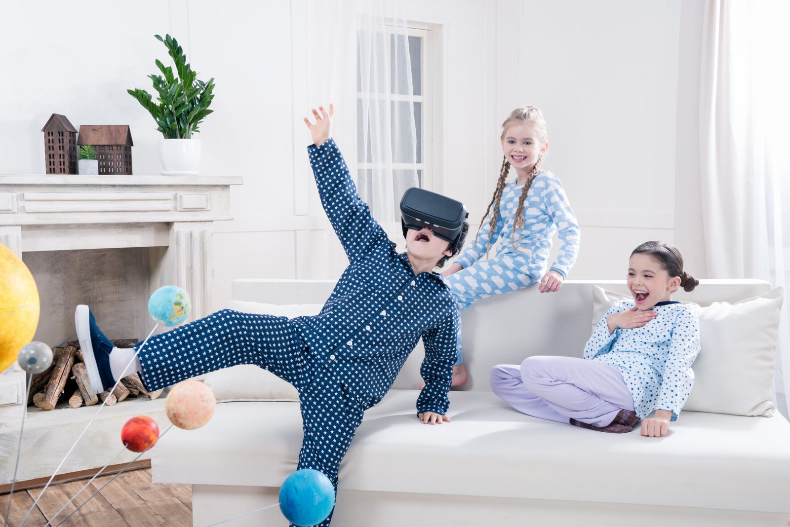 excited kids in pajamas playing with virtual reality headset at home