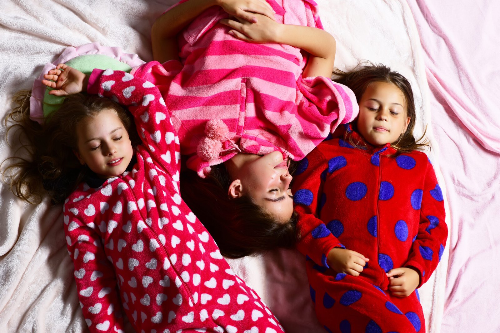 Girl friends in pajamas sleep in bed, top view. Good night, napping, bedtime, slumber, dream, sleepover concept